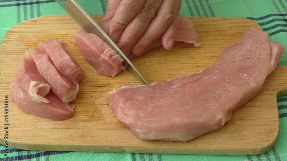 Fresh pork on the chopping board is cut into pieces
Fresh pork on the chopping board is cut into pieces