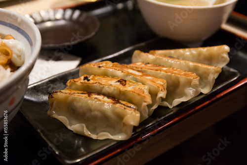 Fried Gyoza or Japanese dumpling on black disk in Japanese restaurant