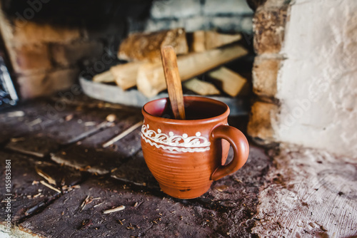 A clay pot with traditional oven on the background
