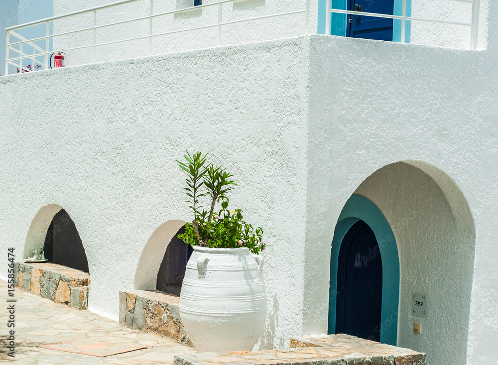Greek architecture - white buildings, sea and blue windows, Bougainvillea on the white wall