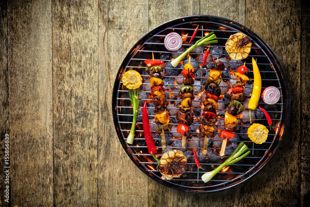 Top view of fresh meat and vegetable on grill placed on wooden floor