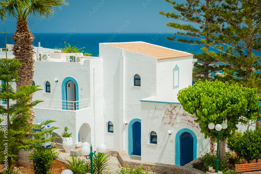 Greek architecture - white buildings, sea and blue windows, Bougainvillea on the white wall