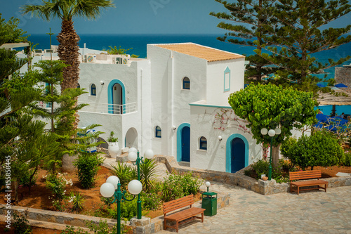 Greek architecture - white buildings, sea and blue windows, Bougainvillea on the white wall