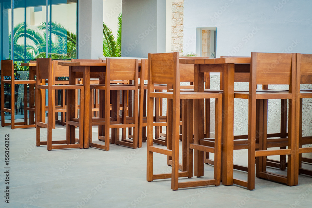 Wooden tables and chairs in seaside Greek restaurant