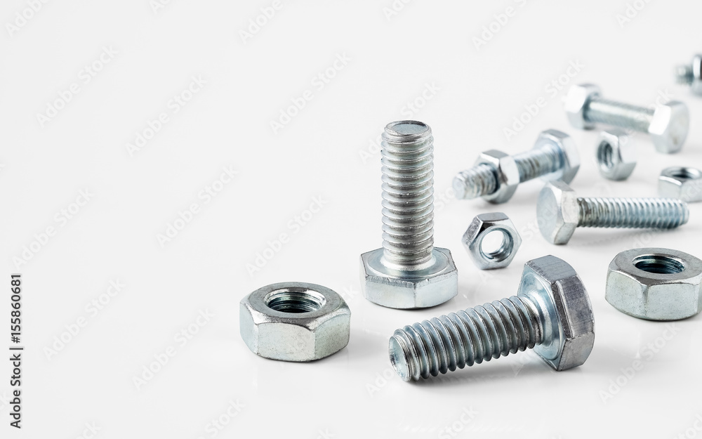 Close-up of various metal steel nuts and bolts on white background with copy space Close-up of various metal steel nuts and bolts on white background with copy space