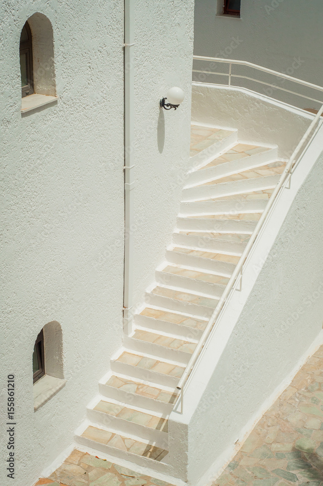 Greek architecture - white buildings, sea and blue windows, stairs