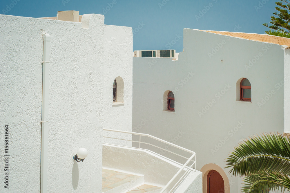 Greek architecture - white buildings, sea and blue windows, stairs