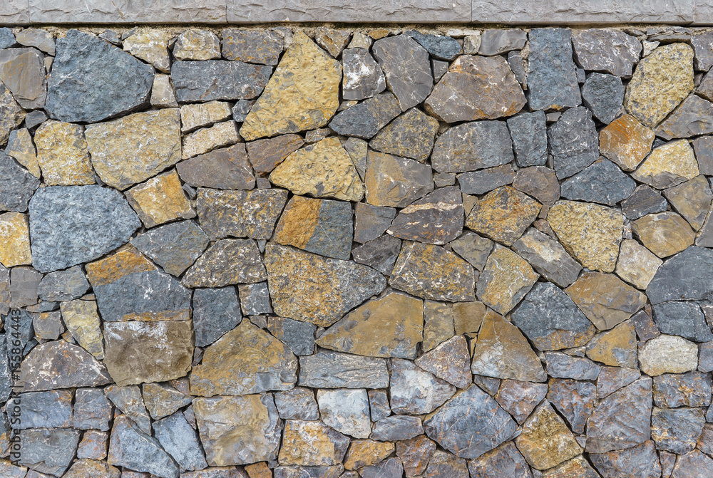 Obraz premium Detail of grey and yellow rocks used as a wall