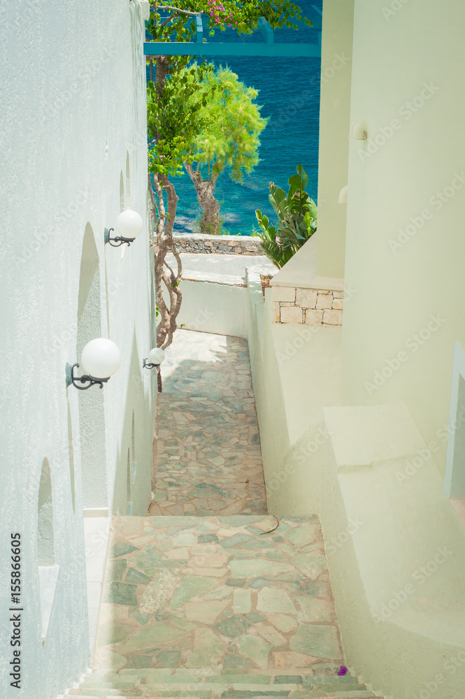 Greek architecture - white buildings, sea and blue windows, stairs