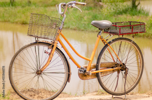 An old bicycle in meadow during sunset with shallow dept of field