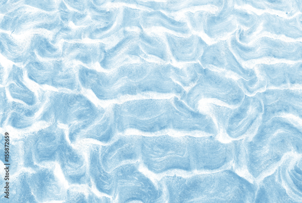 Obraz premium Natural ocean beach sand texture background. Wet sand background with wavy pattern after the tide in light blue color. Close up horizontal composition.