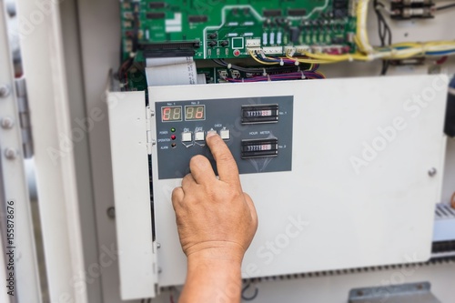The technician is repairing the electrical system. Industrial air conditioning units. A plurality of cooling units installed in the wall of a building.