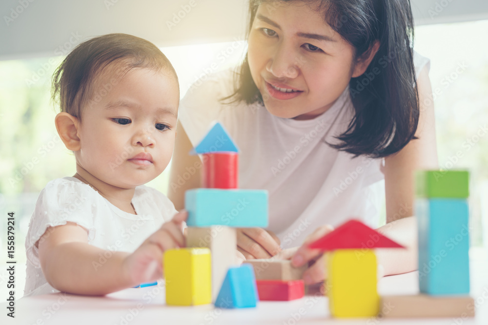 Asian mom and girl kid playing with blocks. Vintage effects and soft light. Asian mom and girl kid playing with blocks. Vintage effects and soft light.