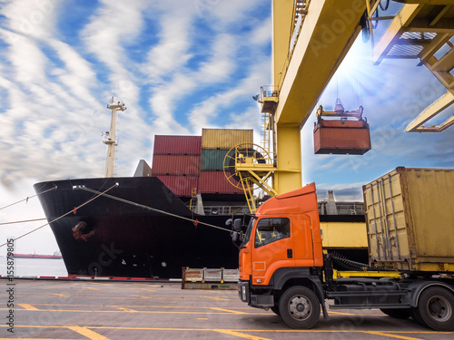 Containers are discharging from vessel by port crane at port of Thailand, Closeup crane to pick up container on truck.
