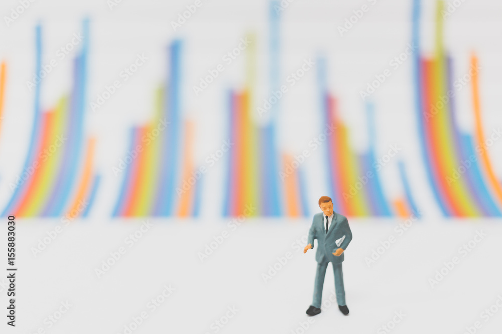 Miniature people businessman standing on chart Miniature people businessman standing on chart