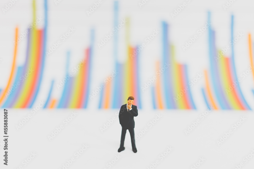 Miniature people businessman standing on chart Miniature people businessman standing on chart