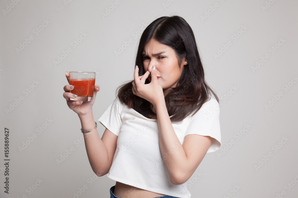 Young Asian woman hate tomato juice. Young Asian woman hate tomato juice.
