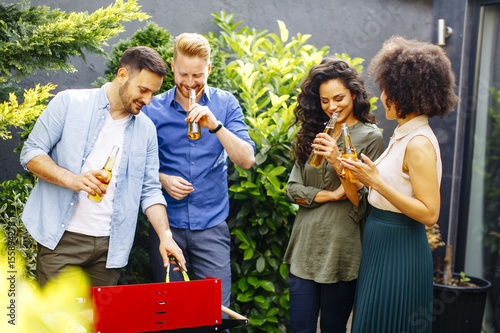 Happy friends grilling food...