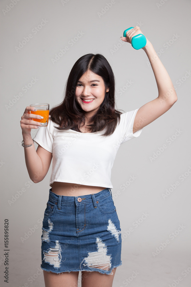 Young Asian woman with dumbbell drink orange juice. Young Asian woman with dumbbell drink orange juice.