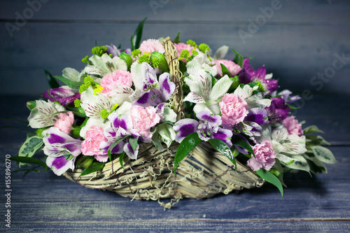 Wedding bouquet in basket on wooden background. Vintage toning