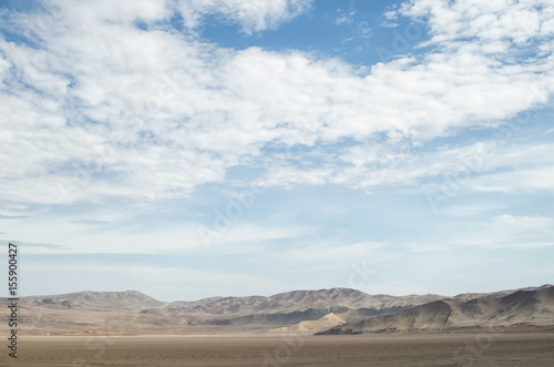Arid lands of the desert under blue cloudy sky © Alice Nerr