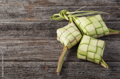 Ketupat (Rice Dumpling) On Wood Background. Ketupat is a natural rice casing made from young coconut leaves for cooking rice during eid Mubarak photo