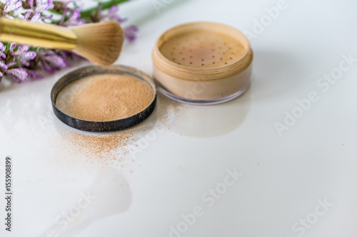 Close-up of mineral, powder, foundation makeup and brush to apply the product. 