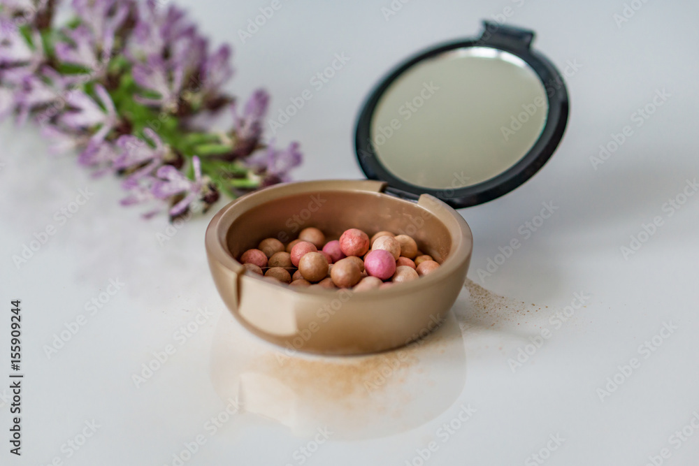 Close-up of makeup pearls, pink and purple on white background. Shallow depth of focus. Concept fashion beauty. Close-up of makeup pearls, pink and purple on white background. Shallow depth of focus. Concept fashion beauty.