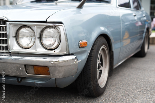 Blue pastel car with the circle headlight in selective focus.