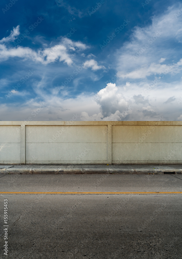 Asphalt road and concrete fence with blue sky Asphalt road and concrete fence with blue sky