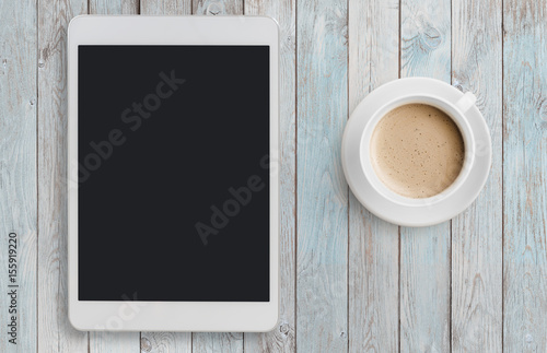 Tablet pc looking like ipad on table with coffee top view