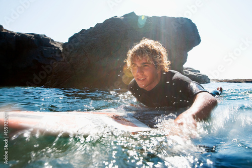 Photography Man lying on surfboard in the water