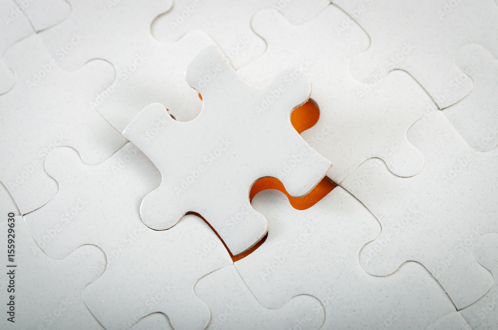Fototapeta premium Completing final task, missing jigsaw puzzle pieces and business concept with a final puzzle piece completing the board on orange background and copy space