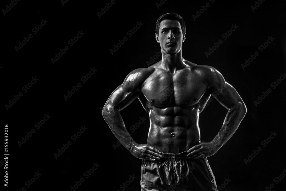 Fototapeta premium Muscular and fit young bodybuilder fitness male model posing ove