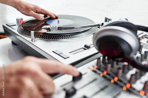 a person using a turntable and mixing board.
