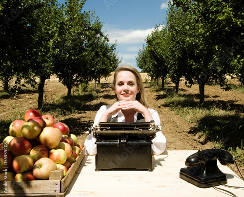 Woman sitting at desk in orchard. photo