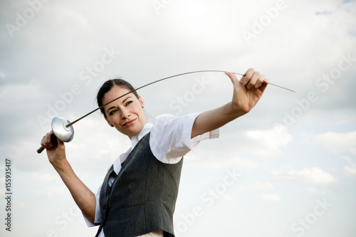 Woman with sword in wheat field. photo