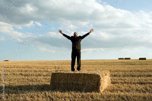 Man standing on hay in wheat field. photo