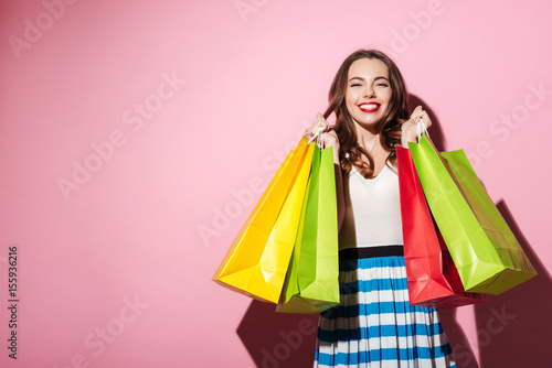 Happy girl carrying colorful shopping bags