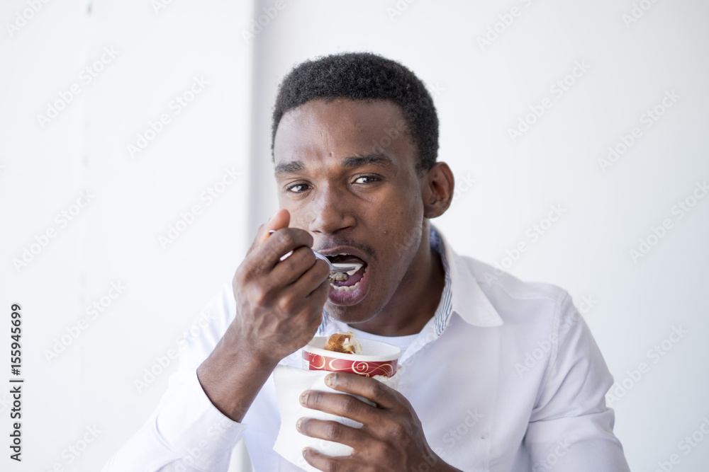 Black man eating ice cream with spoon Stock Photo Adobe Stock