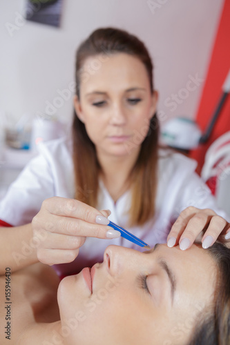 Beautician working on customer's face