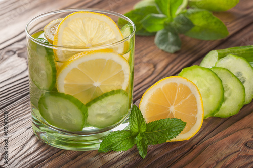 cool drink with lemon and mint on a wooden background