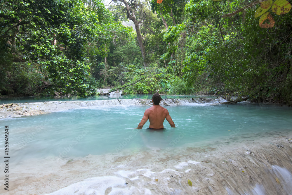 Obraz premium Man wading in tropical paradise pool