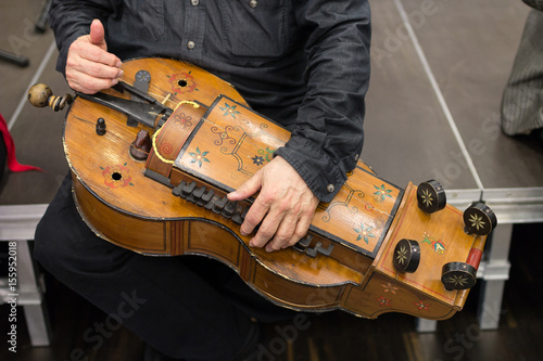Foto Musician hands holding instrument hurdy-gurdy with Hungarian folk ornaments