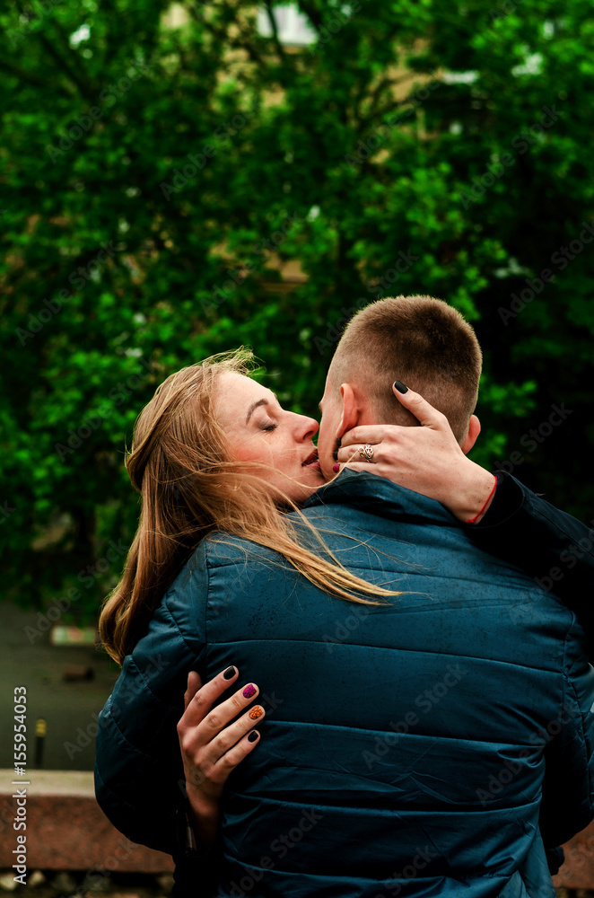 Fototapeta premium rainy weather. The wind develops the girl's hair. Tender kiss