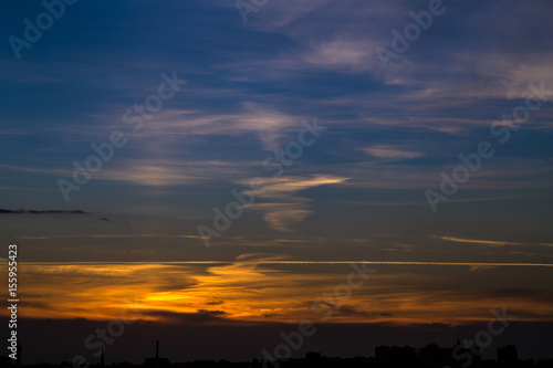 the evening sky, the sunset clouds on the background of the city