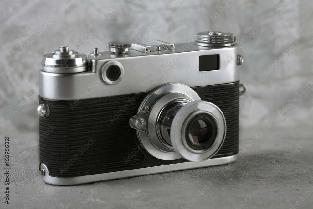 Old rangefinder camera on gray cement background.