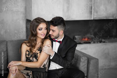 Woman in elegant dress sitting with handsome man in black suit.
