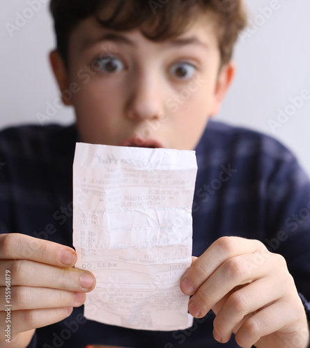 teenager boy shocked expression after see bill for pizza in fast food restaurant photo