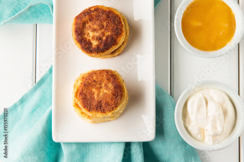 Cottage cheese pancakes on a wooden white background, horizontal, top view, soft focus
